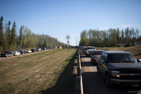 Residents of Fort McMurray line up for gas after they were ordered to be evacuated due to raging wildfires, in Anzac, Alberta, Canada May 4, 2016. REUTERS/Topher Seguin