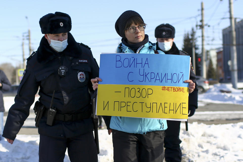 FILE - Police detain a demonstrator with a poster which reads "The war with Ukraine is a shame and a crime" during an action against Russia's attack on Ukraine in Omsk, Russia, Sunday, Feb. 27, 2022. Western countries on Monday repeatedly called on Russia to end domestic repression of dissident voices and end its war in Ukraine and human rights violations related to it, as Russia came under a regular review at the U.N.’s top rights body. (AP Photo/Evgeniy Sofiychuk, File)