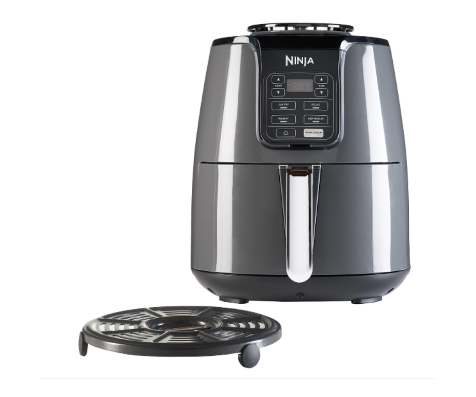 Ninja's Air Fryer in dark grey against a white background with the circular heating disc on the left infront of it