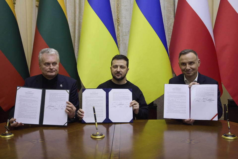 In this photo provided by the Ukrainian Presidential Press Office, Ukrainian President Volodymyr Zelenskyy, centre, Polish President Andrzej Duda, right, and Lithuania's President Gitanas Nauseda pose for a photo with signed documents during their meeting in Lviv, Ukraine, Wednesday, Jan. 11, 2023. (Ukrainian Presidential Press Office via AP)