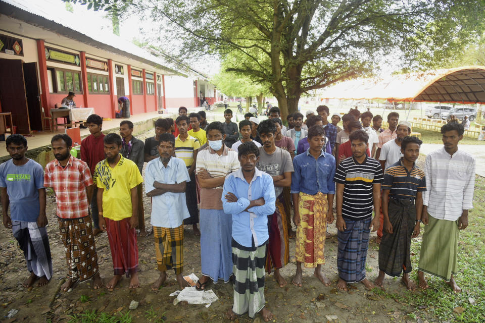 Ethnic Rohingya men line up as they wait for a registration process by UNHCR at a temporary shelter in Pidie, Aceh province, Indonesia, Tuesday, Dec. 27, 2022. The United Nations agency is seeking information about the voyage of over 100 Rohingya Muslim refugees who landed on an Indonesian beach this week, and warned Tuesday that there will likely be more. (AP Photo/Rahmat Mirza)