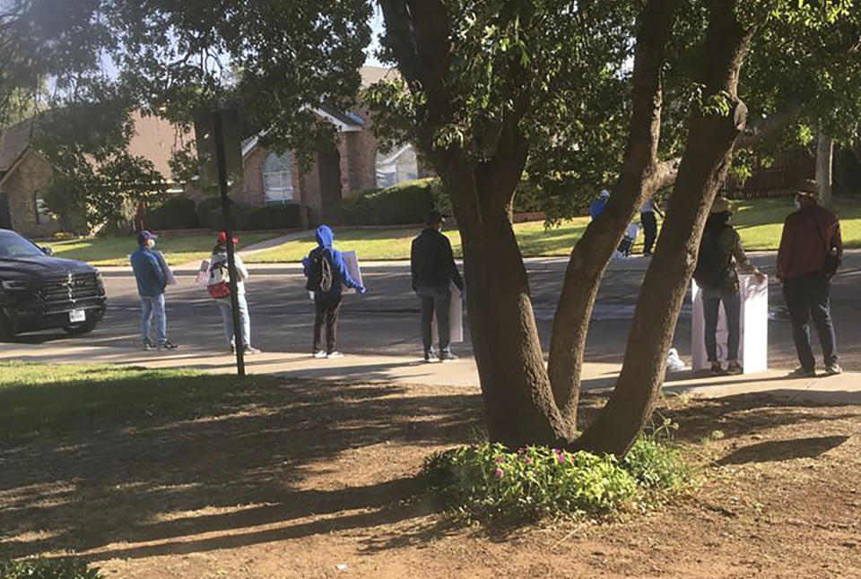 Protestors hold signs and chant outside Bob Fu's home in Midland, Texas in the Fall of 2020, accusing the Chinese-American Christian pastor of being a spy for the Chinese Communist Party. American officials say foreign countries like Iran and China intimidate, harass and sometimes plot violence against political opponents and activists in the U.S. Fu, whose organization, ChinaAid, advocates for religious freedom in China, said he has endured far-ranging harassment campaigns for years. Large crowds arriving at his home by bus in well-coordinated actions he believes can be linked to the Chinese government. (Bob Fu via AP)