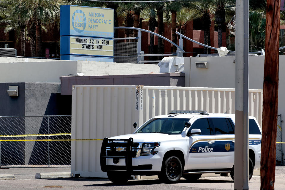 Fire investigators stand outside the Arizona Democratic Party headquarters Friday, July 24, 2020, in Phoenix. Fire investigators are looking into the cause of an early morning blaze that destroyed part of the Arizona and Maricopa County Democratic Party headquarters Friday. (AP Photo/Matt York)