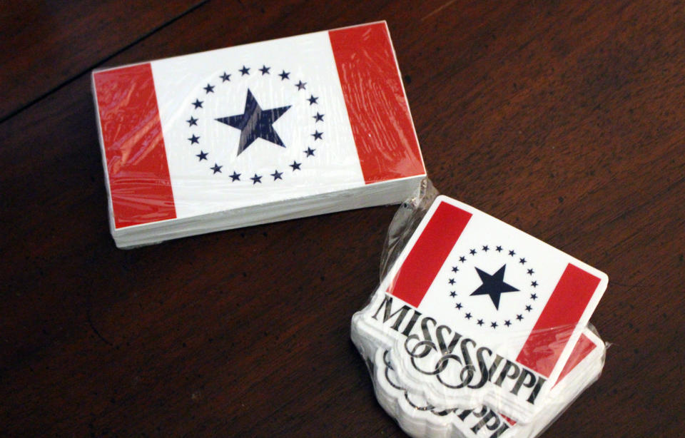 In this April 17, 2019, photo, plastic-wrapped cards and stickers of the "Stennis flag", designed by a graphic design Laurin Stennis, sit on table in her home in Jackson, Miss. She designed the flag as a proposal to replace the current Mississippi state flag, which has been used since 1894 and includes the Confederate battle emblem that critics see as racist. Although the current flag is not changing, Republican Gov. Phil Bryant has signed a bill authorizing the state to sell several new specialty license plates, including one featuring the "Stennis flag." (AP Photo/Emily Wagster Pettus)