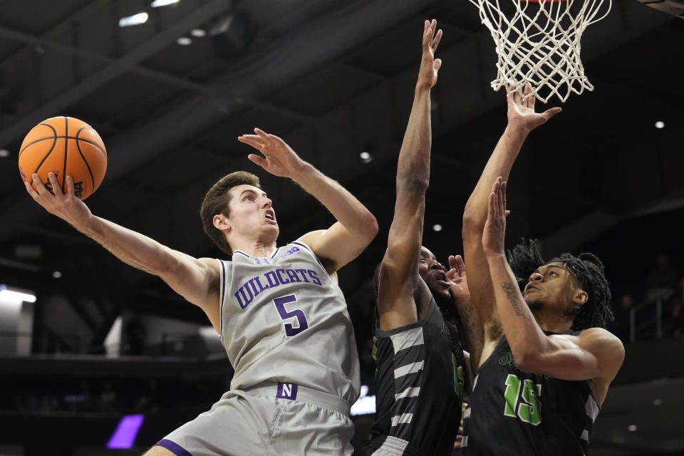 Northwestern guard Ryan Langborg, left, drives to the basket against Chicago State guard Brent Davis, center, and forward Noble Crawford during the first half of an NCAA college basketball game in Evanston, Ill., Wednesday, Dec. 13, 2023. (AP Photo/Nam Y. Huh)