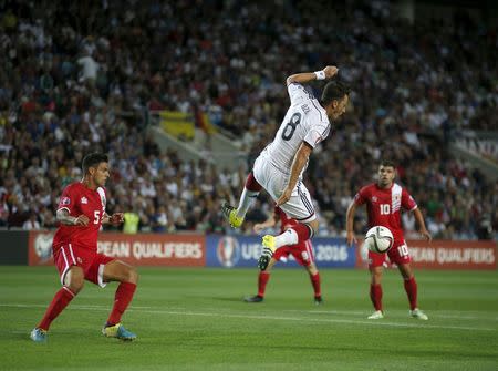 Germany's Mesut Ozil (C) jumps to control the ball in front of Gibraltar's Ryan Casciaro (L), Liam Walker (R) and Kyli Casciaro during their Euro 2016 qualifying soccer match at Algarve stadium in Faro, Portugal, June 13, 2015. REUTERS/Rafael Marchante