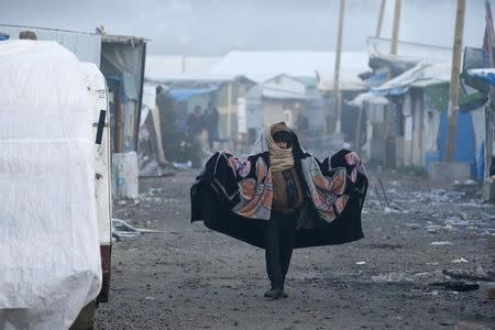 A migrant walks past makeshift shelters on the second day of their evacuation and transfer to reception centers in France, during the dismantlement of the camp called the "Jungle" in Calais, France, October 25, 2016. REUTERS/Pascal Rossignol