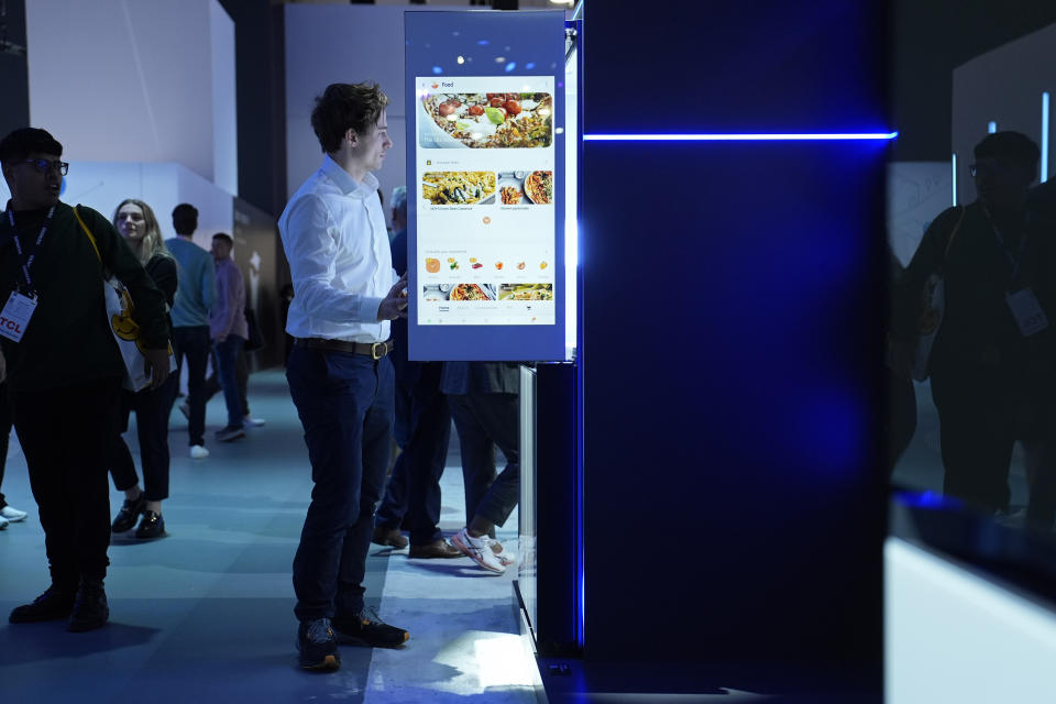 A person stands by a Samsung Bespoke AI Family Hub refrigerator at the Samsung booth during the CES tech show Tuesday, Jan. 9, 2024, in Las Vegas. (AP Photo/John Locher)