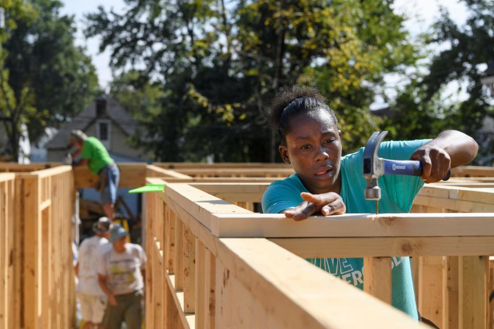A woman builds walls for her future home with the help of Habitat for Humanity builders and other future homeowners needing "sweat equity" hours . Every future homeowner has to secure "sweat equity" hours through a combination of attending homeowner education courses, community service, physical labor through home building and working in Habitat's ReStore.