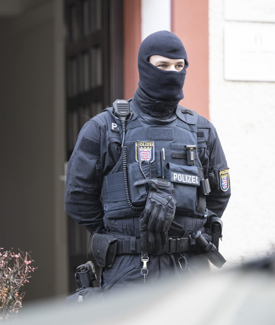 Police officers stand by a searched property in Frankfurt during a raid against so-called 'Reich citizens' in Frankfurt, Germany, Wednesday, Dec. 7, 2022. Thousands of police carried out a series of raids across much of Germany on Wednesday against suspected far-right extremists who allegedly sought to overthrow the state by force. Federal prosecutors said some 3,000 officers conducted searches at 130 sites in 11 of Germany's 16 states against adherents of the so-called Reich Citizens movement. Some members of the grouping reject Germany's postwar constitution and have called for the overthrow of the government. (Boris Roessler/dpa via AP)