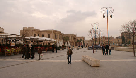 People walk near Aleppo's historic citadel, Syria December 11, 2009. REUTERS/Khalil Ashawi