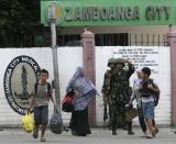 A government soldier directs civilian evacuees near an area where Muslim rebels members of the Moro National Liberation Front (MNLF) is occupying villages in Zamboanga City, southern Philippines September 9, 2013. Muslim rebels took 30 civilian hostages in the southern Philippines on Monday and held security forces in a standoff as part of a drive to derail peace talks, officials said. Police commandos cordoned off parts of Zamboanga City on the island of Mindanao after a rogue faction of the MNLF took hostages and tried to march to the city hall to raise their flag, an army commander said. REUTERS/STRINGER (PHILIPPINES - Tags: POLITICS MILITARY CIVIL UNREST)