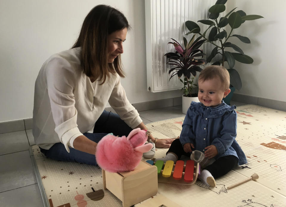 Sandrine Rudnicki, a 38 years old single woman smiles to her 10-month old daughter Emilia who was conceived through in-vitro fertilization, Monday Oct.14, 2019 in Saint-Pryve-Saint-Mesmin, near Orleans, France. France's lower house of parliament is set to adopt a bill that would give single women and lesbian couples access to in-vitro fertilization and related procedures. (AP Photo/Catherine Gaschka)