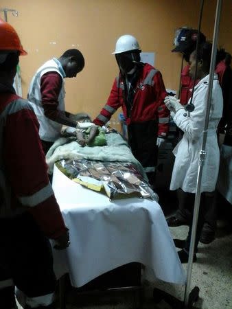 Kenya Red Cross paramedics attend to a 18-month-old girl rescued from the rubble of a six-storey building that collapsed after days of heavy rain, in Nairobi, May 3, 2016. Bonny Odhiambo/Kenya Red Cross/Handout via Reuters