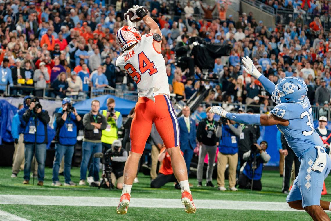 Clemson tight end Davis Allen (84) catches the ball for a touchdown while covered by North Carolina linebacker Cedric Gray (33) in the first half during the Atlantic Coast Conference championship NCAA college football game on Saturday, Dec. 3, 2022, in Charlotte, N.C. (AP Photo/Jacob Kupferman)