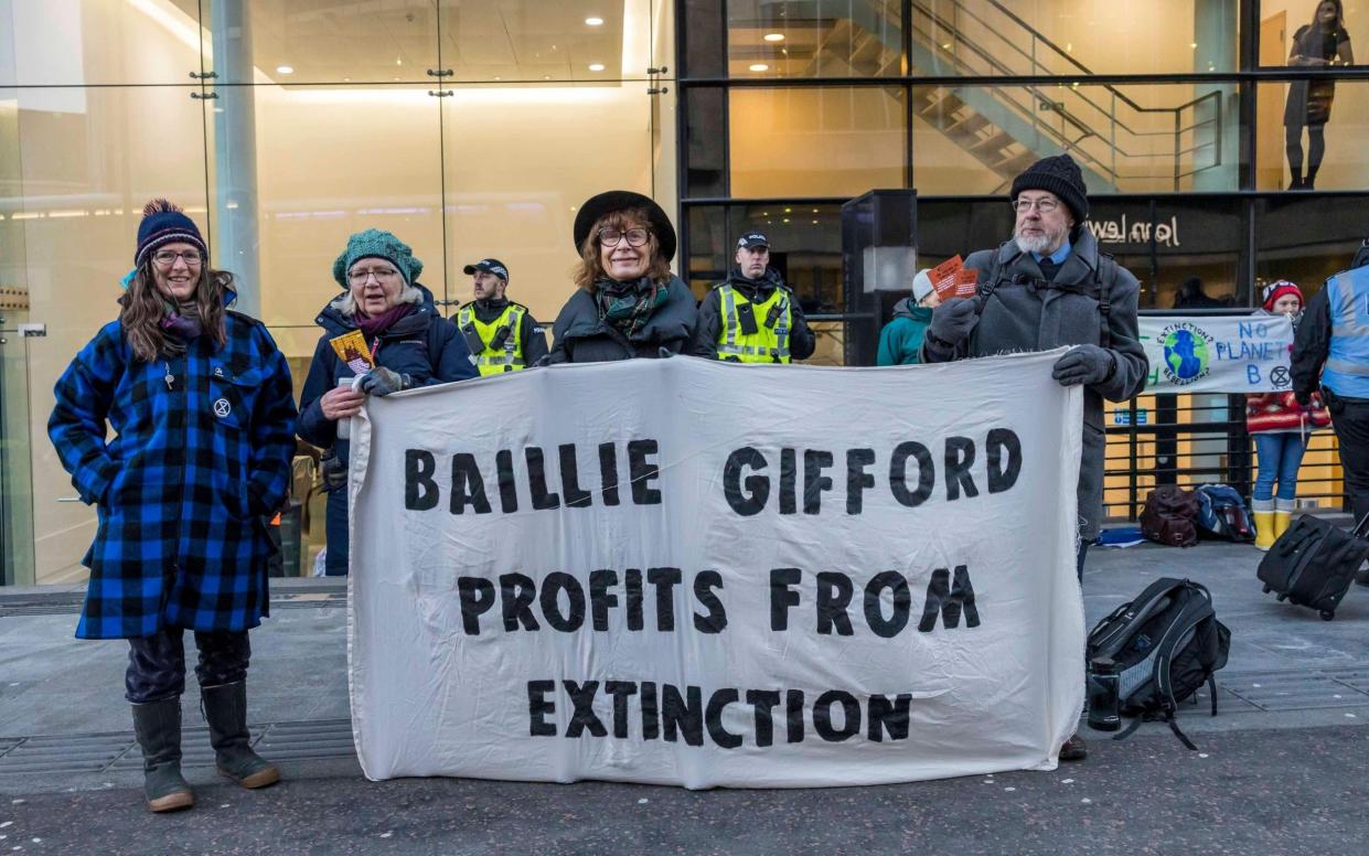 A small group of protesters hold a single banner