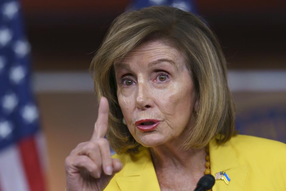 Nancy Pelosi raises an index finger as she speaks.