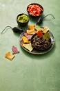 <p>Cut tortilla chips into the shape of gravestones and serve with salsa, guac and black bean dip.</p>