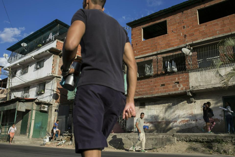 People walk where where Nick Samuel Oropeza, 19, was killed when anti-government protests broke out the previous week in Caracas, Venezuela, Wednesday, Jan. 30, 2019. Human Rights Watch has detailed widespread abuses by members of Venezuela's security forces in reports published in 2014 and 2017. (AP Photo/Rodrigo Abd)