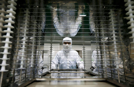 An employee works inside an electronic products factory in Huzhou, Zhejiang province, June 25, 2013. REUTERS/William Hong/File Photo