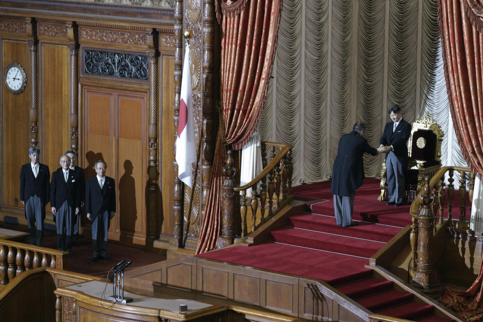 Japan's Emperor Naruhito, right, hands over a statement after reading it to open formally an extraordinary session at the upper house of parliament in Tokyo Thursday, Aug. 1, 2019. Naruhito delivered his first opening speech since ascending to the Chrysanthemum Throne on May 1. (AP Photo/Eugene Hoshiko)