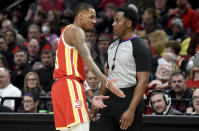 Atlanta Hawks guard Dejounte Murray, left, speaks with referee Mitchell Ervin, right, after being called for a foul during the second half of an NBA basketball game against the Portland Trail Blazers in Portland, Ore., Monday, Jan. 30, 2023. The Blazers won 129-125. (AP Photo/Steve Dykes)