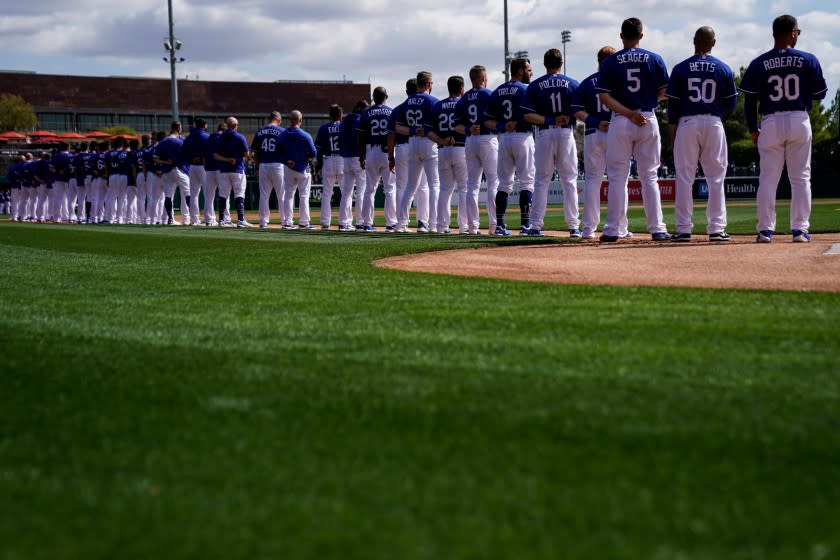PHOENIX, ARIZ. - FEBRUARY 23: The Los Angeles Dodgers stand during the singing of the national anthem.