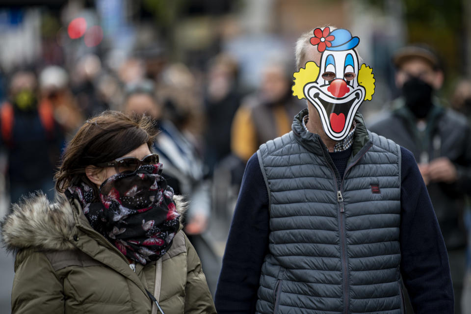 10.10.2020, Berlin: Ein Teilnehmer der Demonstration «Wir müssen reden» läuft mit einer Clownsmaske aus Papier durch die Berliner Innenstadt. Die Veranstalter der Demo rufen zu einem Schweigemarsch auf, um gegen die Corona-Maßnahmen zu demonstrieren. Foto: Fabian Sommer/dpa +++ dpa-Bildfunk +++
