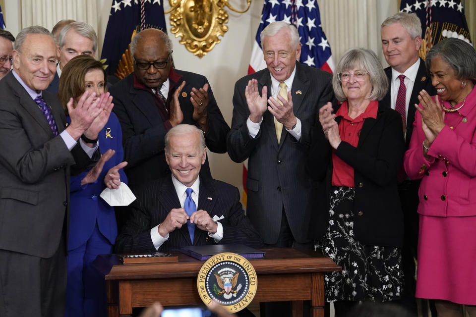 President Joe Biden smiles after signing the Postal Service Reform Act of 2022 in the State Dining Room at the White House in Washington, Wednesday, April 6, 2022. Watching from left are Senate Majority Leader Chuck Schumer of N.Y., Sen. Rob Portman, R-Ohio, House Speaker Nancy Pelosi of Calif., Rep. James Clyburn, D-S.C., Rep. Steny Hoyer, D-Md., Annette Taylor, Rep. James Comer, R-Ky., and Rep. Brenda Lawrence, D-Mich. (AP Photo/Susan Walsh)