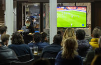 FILE - In this Tuesday March 10, 2020 filer, waiters wearing masks serve food and drink in a terrace outside Mestalla stadium during the Champions League round of 16 second leg soccer match between Valencia and Atalanta in Valencia, Spain. It was the biggest soccer game in Atalanta’s history and a third of Bergamo’s population made the short trip to Milan’s famed San Siro Stadium to witness it. Nearly 2,500 fans of visiting Spanish club Valencia also traveled to the Champions League match. More than a month later, experts are pointing to the Feb. 19 game as one of the biggest reasons why Bergamo has become one of the epicenters of the coronavirus pandemic — a “biological bomb” was the way one respiratory specialist put it — and why 35% of Valencia’s team became infected. The new coronavirus causes mild or moderate symptoms for most people, but for some, especially older adults and people with existing health problems, it can cause more severe illness or death. (AP Photo/Alberto Saiz, File)