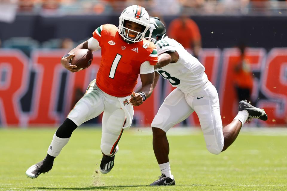 Miami quarterback D'Eriq King (1) breaks a tackle from Michigan State cornerback Kalon Gervin (18) during the second quarter of an NCAA college football game, Saturday, Sept. 18, 2021, in Miami Gardens, Fla.