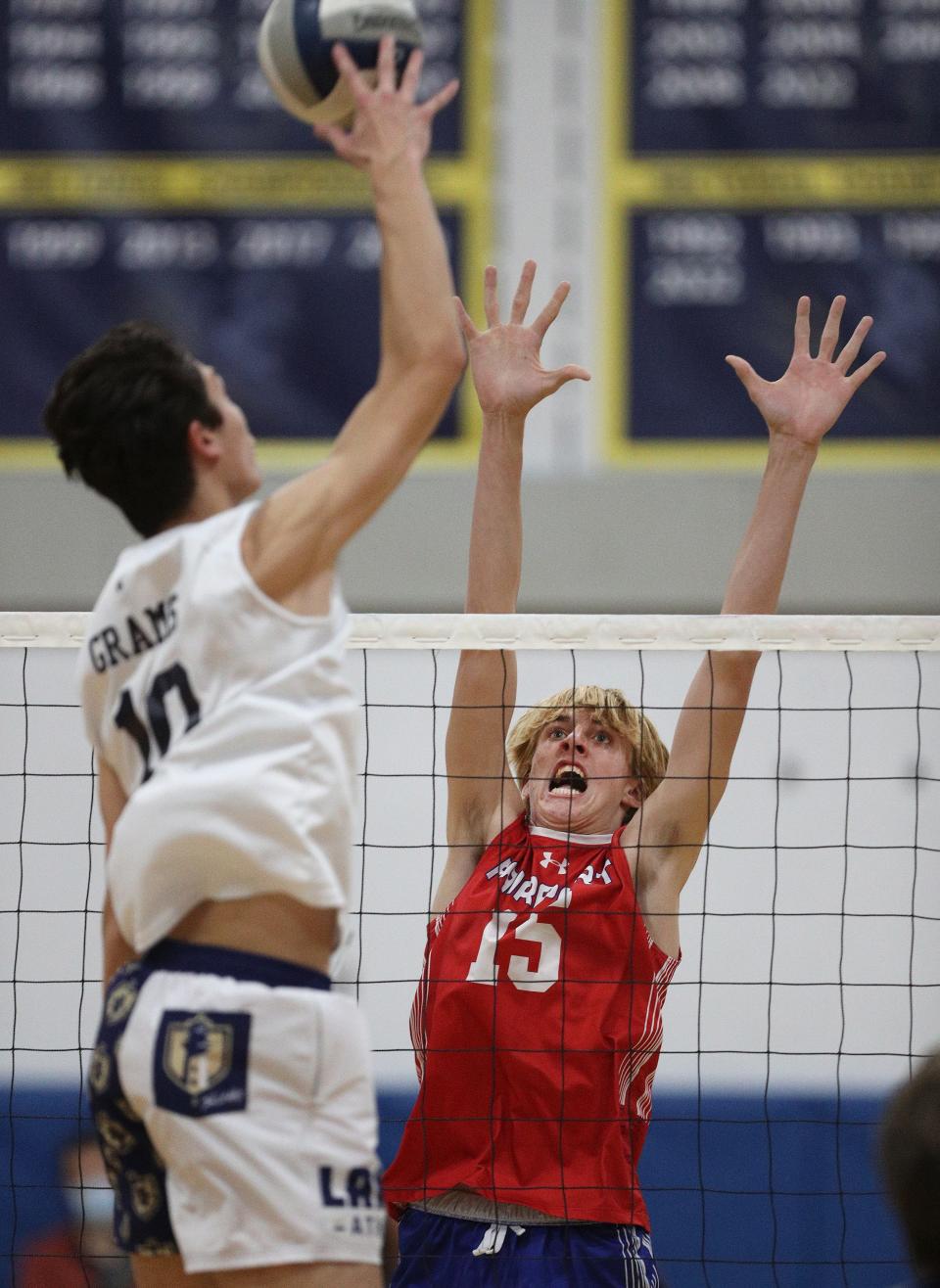 Webster’s Jacob Grams goes up for the kill over Fairport’s Luke Sullivan. 