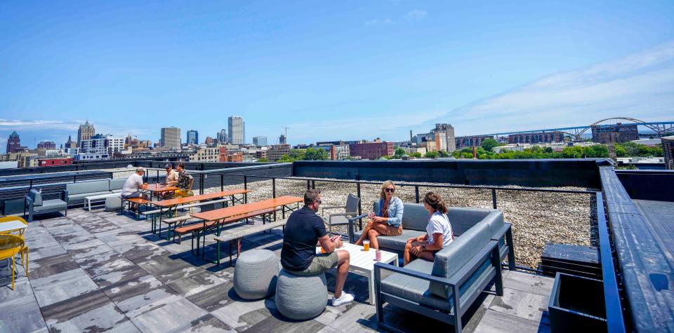 Kyle Woulf, from left, Darcy Gehrke and Jasara Woulf enjoy views on July 8, 2023 from Indeed Brewing's UpTop rooftop, Gehrke's favorite spot in Milwaukee overlooking the city's skyline and the Hoan Bridge. The Woulfs were visiting from Madison.