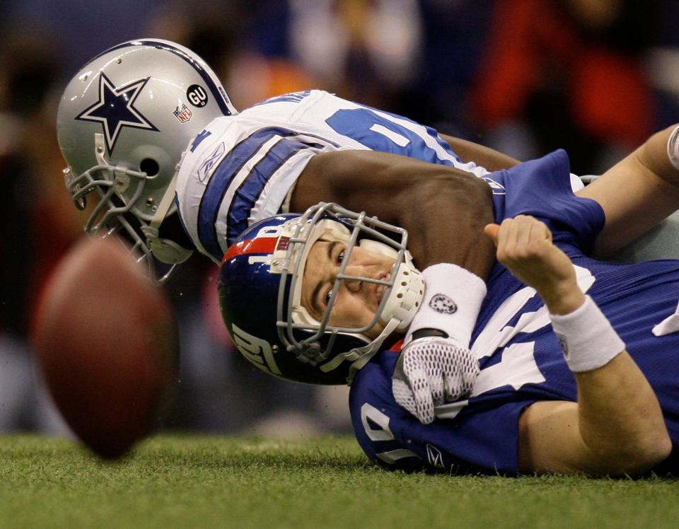 New York Giants quarterback Eli Manning (10) fumbles after he was sacked by Dallas Cowboys linebacker DeMarcus Ware (94) during the first quarter of an NFL football game Sunday, Dec. 14, 2008, in Irving, Texas. The Giants recovered the ball. (AP Photo)