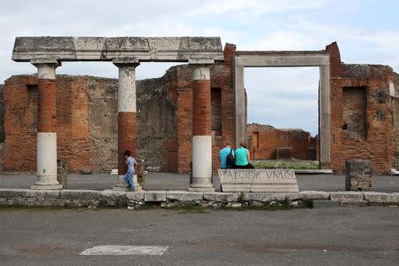 Tourists visit an ancient Roman cobbled street at the UNESCO World Heritage site of Pompeii, October 13, 2015. REUTERS/Alessandro Bianchi