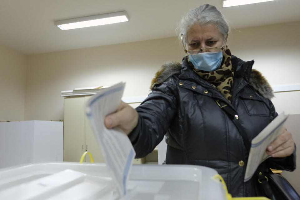 A woman casts her ballot for the local elections at a polling station in Mostar, Bosnia, Sunday, Dec. 20, 2020. Divided between Muslim Bosniaks and Catholic Croats, who fought fiercely for control over the city during the 1990s conflict, Mostar has not held a local poll since 2008, when Bosnia's constitutional court declared its election rules to be discriminatory and ordered that they be changed. (AP Photo/Kemal Softic)