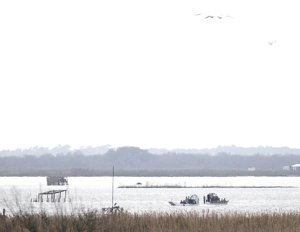 Emergency personnel work at the scene of a plane crash site in Trinity Bay in Anahuac, Texas on Saturday, Feb. 23, 2019. The Federal Aviation Administration said a Boeing 767 cargo plane went down approximately 30 miles southeast of Houston's George Bush Intercontinental Airport. (Brett Coomer/Houston Chronicle via AP)