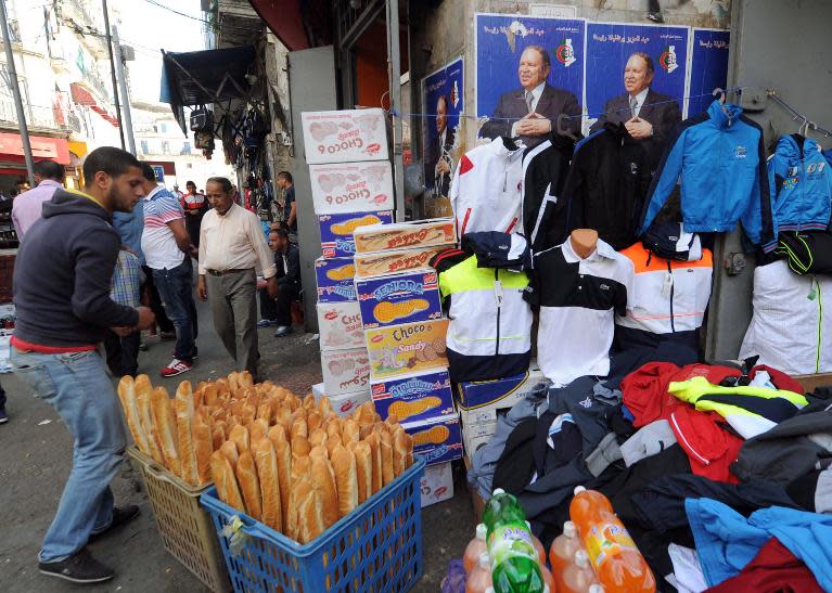 Posters of Algerian President Abdelaziz Bouteflika and candidate in upcoming presidential elections pictured next to a street vendor in the capital Algiers on April 15, 2014