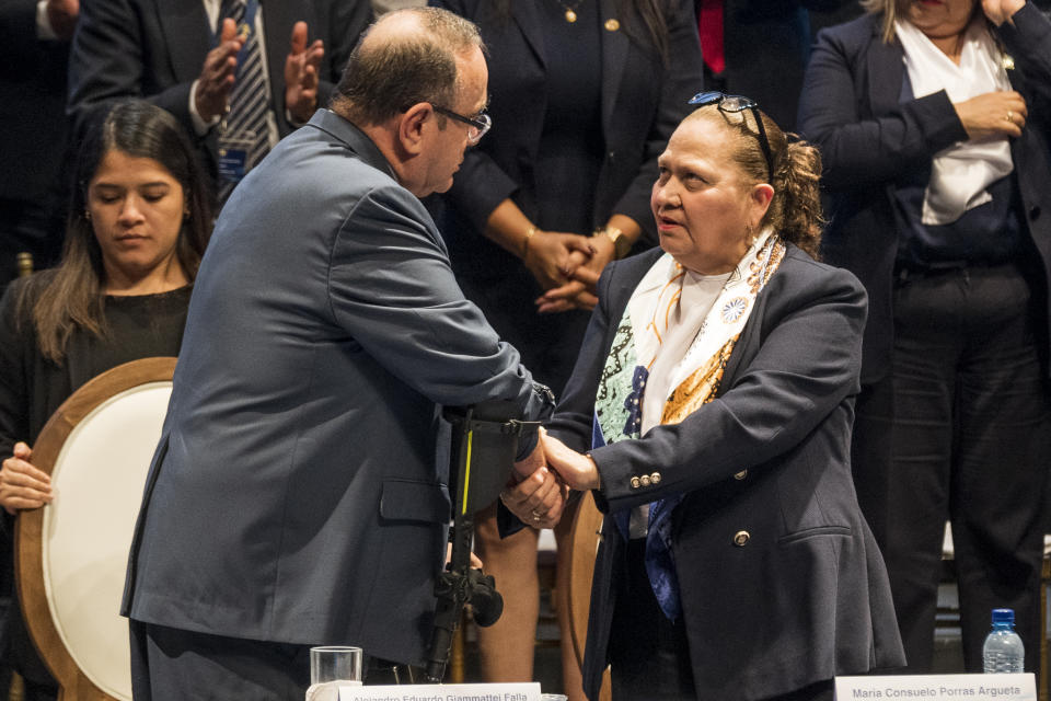 ARCHIVO - El presidente de Guatemala Alejandro Giammattei saluda a la fiscal general, Consuelo Porras, tras la entrega de su informe anual en Ciudad de Guatemala, el 17 de mayo de 2023. Porras, que fue inicialmente designada en 2018 por el entonces presidente Jimmy Morales, fue ratificada por Giammattei en 2022, la primera vez en que Guatemala renueva a un fiscal general para un segundo periodo. (AP Foto/Moisés Castillo, Archivo)