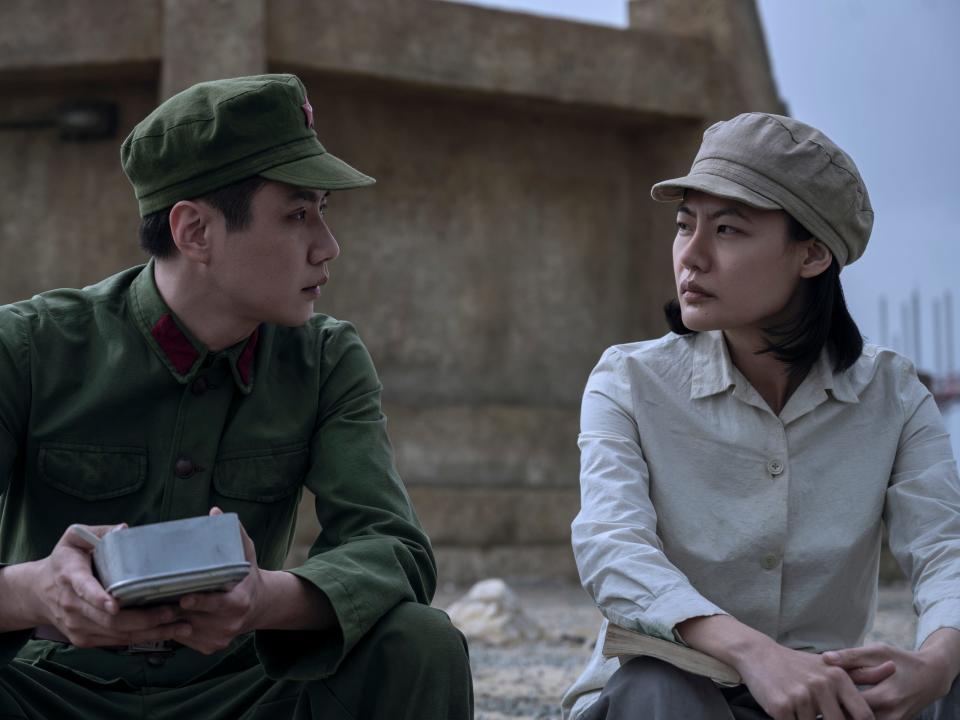 yang weining and ye wenjie sitting outside in three body problem, wearing utilitarian clothing