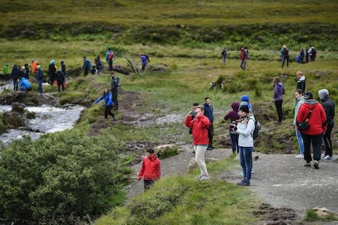 Tourists at the Fairy Pools, one of Skye's most popular attractions - Credit: Getty