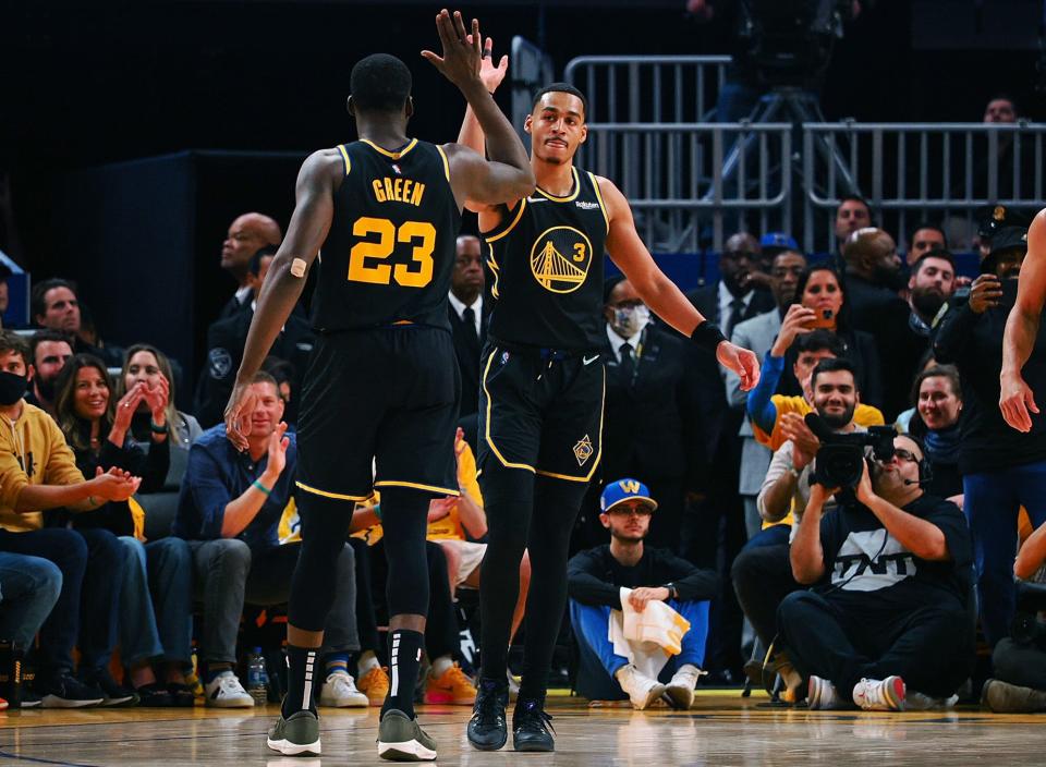 The Golden State Warriors' Jordan Poole (3) high fives Draymond Green (23) after a play against the Dallas Mavericks during game five of the 2022 western conference finals on May 26, 2022.