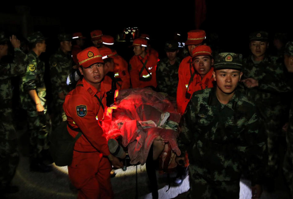 Chinese paramilitary police carry a survivor