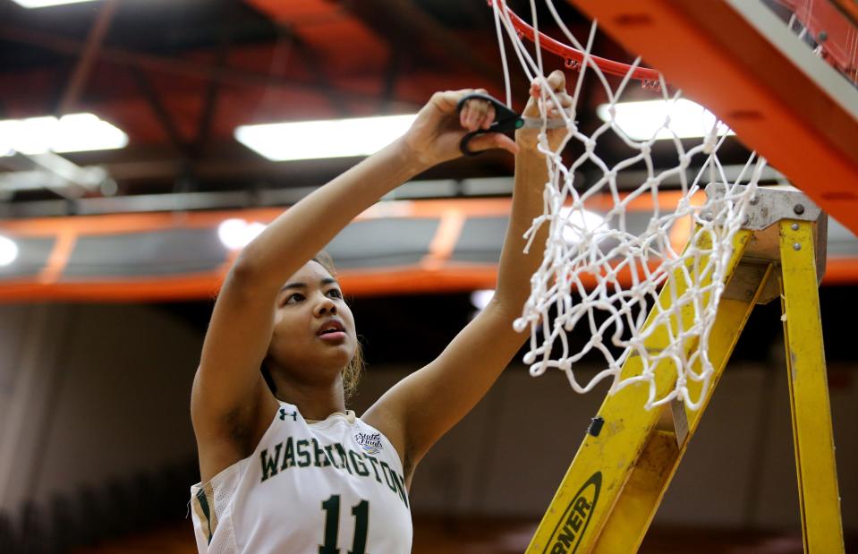 WashingtonÕs Kira Reynolds (11) cuts down the nets after a victory against Valparaiso Saturday, Feb. 11, 2023, at the girls 4A basketball regional game at LaPorte High School. Washington won, 60-41, to advance.