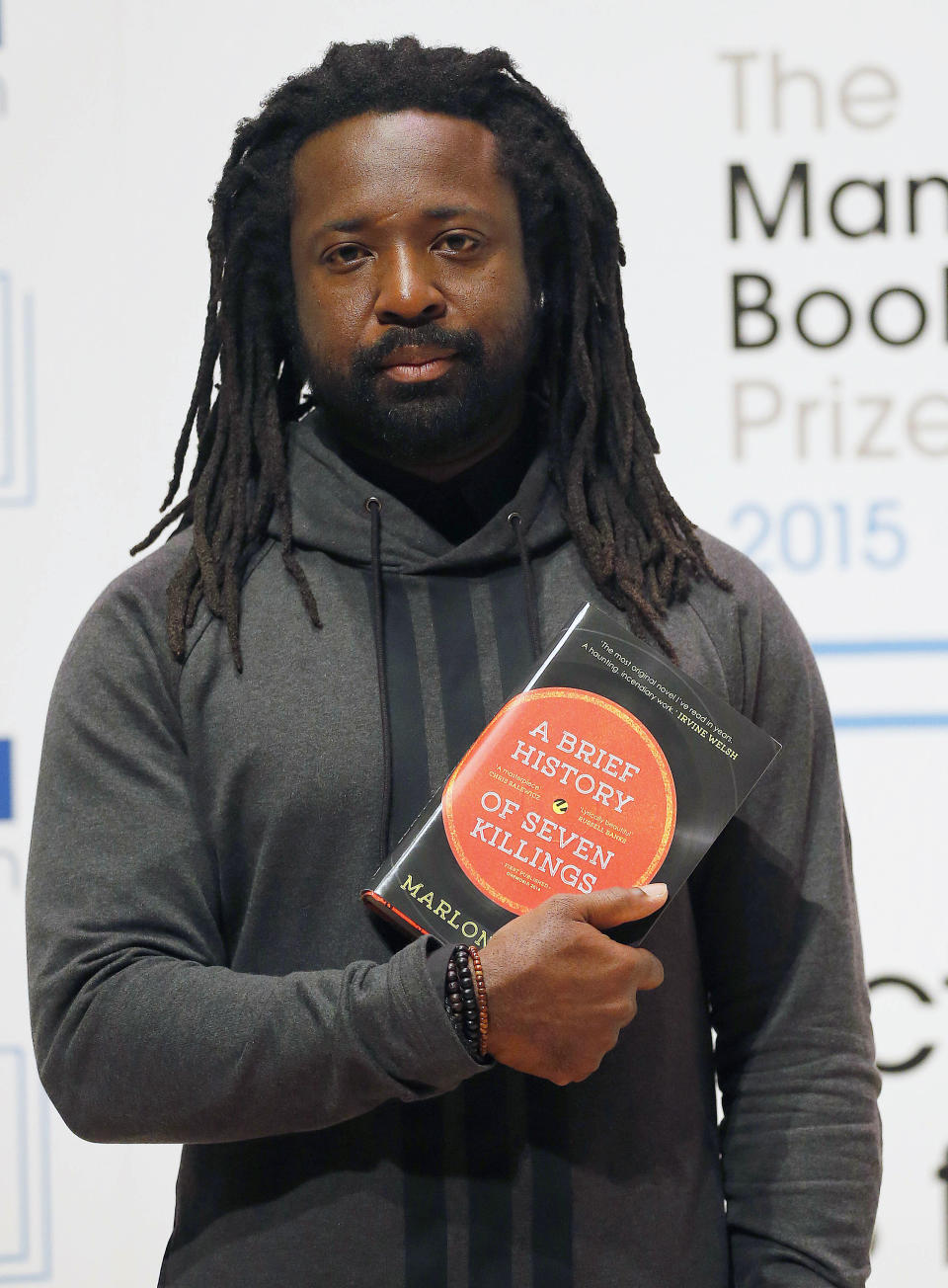 FILE - In this Oct. 12, 2015 file photo, author Marlon James poses with his book "A Brief History of Seven Killings" in London. Author of four novels, the 48-year-old James has made an art of “finding what would rather stay lost,” as he writes in his new work, “Black Leopard, Red Wolf.” (AP Photo/Frank Augstein, File)