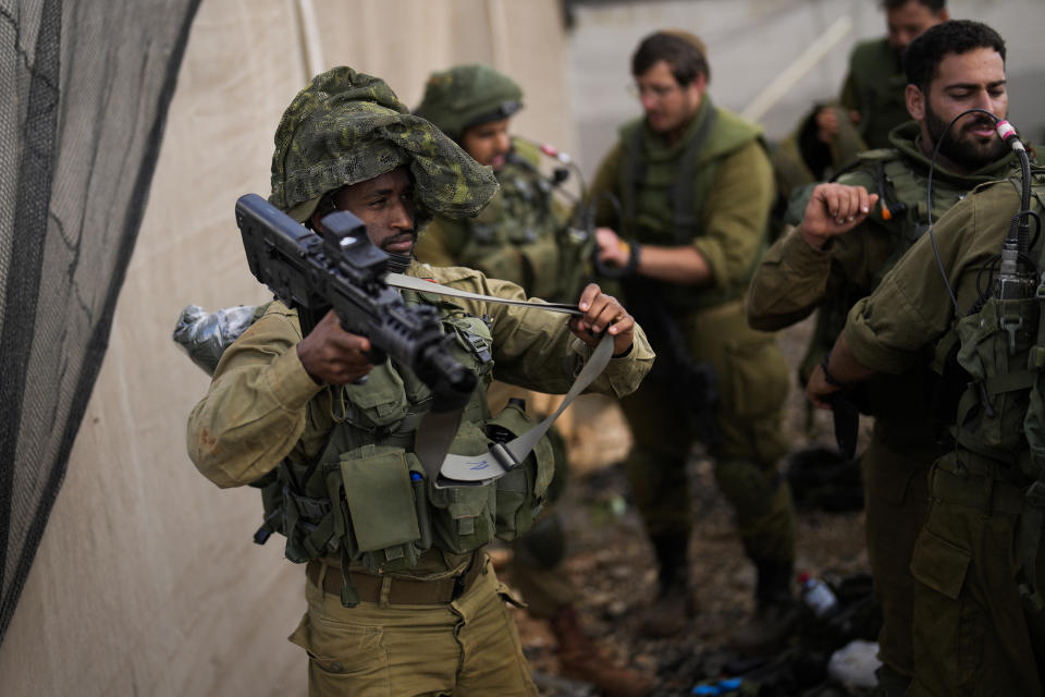 Israeli soldiers get ready to patrol along a road near the border between Israel and Lebanon, Monday, Oct. 16, 2023. (AP Photo/Francisco Seco)