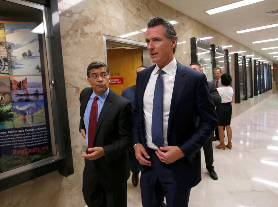 California Gov. Gavin Newsom, right, and Attorney General Xavier Becerra, leave a news conference where they announced the state has filed a lawsuit against the Trump administration's new rules blocking green cards for many immigrants.