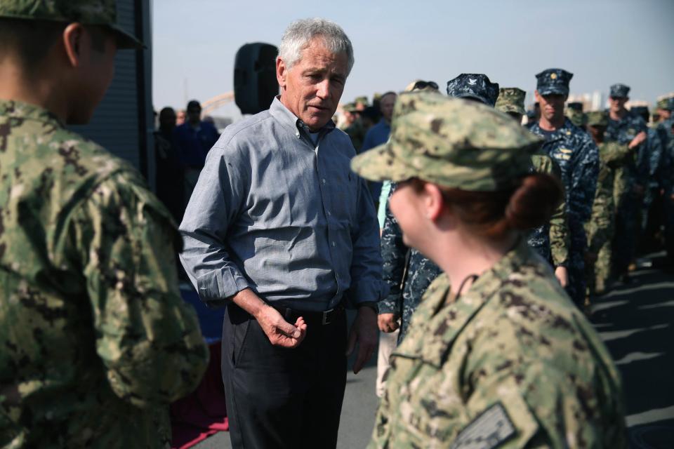 U.S. Secretary of Defense Chuck Hagel gives out commemorative coins to military servicemembers aboard the USS Ponce in Manama