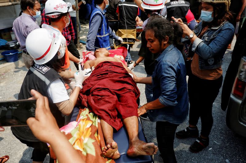 Wounded Buddhist monk receives treatment from a medical staff amid protests against the military coup in Mandalay