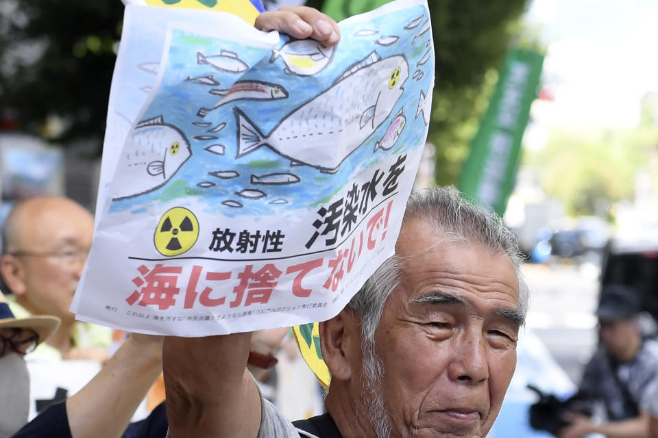 A protester holds a sign which reads "Do not discharge the wastewater into the sea" during a rally against the treated radioactive water release from the damaged Fukushima nuclear power plant, in front of Tokyo Electric Power Company Holdings (TEPCO) headquarters, Thursday, Aug. 24, 2023, in Tokyo. The operator of the tsunami-wrecked Fukushima Daiichi nuclear power plant will begin releasing the first batch of treated and diluted radioactive wastewater into the Pacific Ocean later Thursday, utility executives said.(AP Photo/Norihiro Haruta)